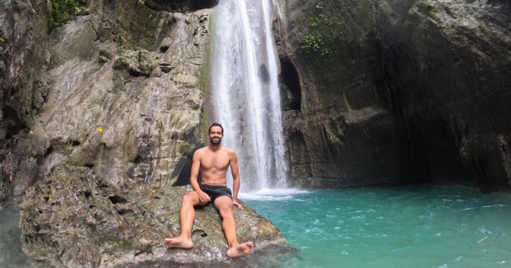 David sitting underneath a waterfall